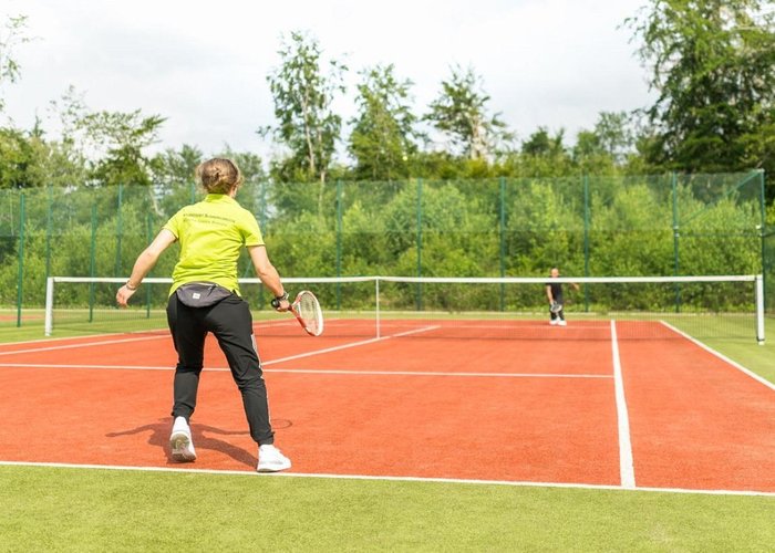 Tennis players on one of the two tennis courts at Naturresort Schindelbruch