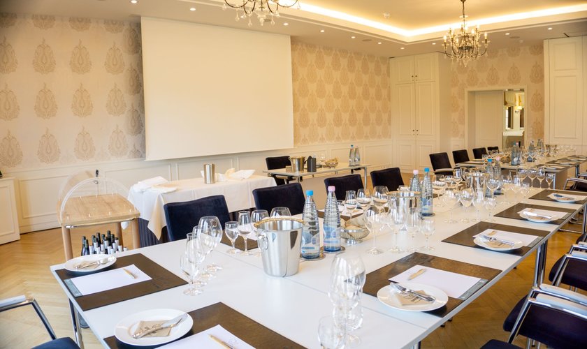 A conference room with conference tables in block form and conference drinks on the tables.