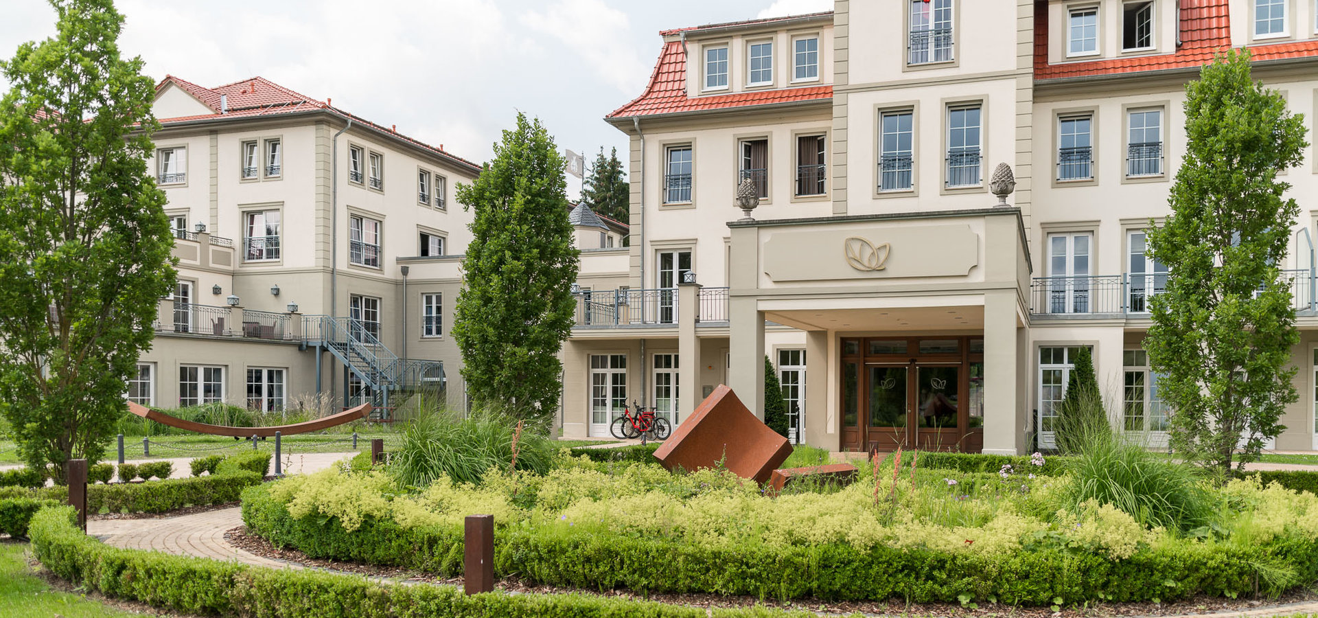 Das Wellnesshotel in grüner Natur eingebettet mit Anfahrtsschleife.