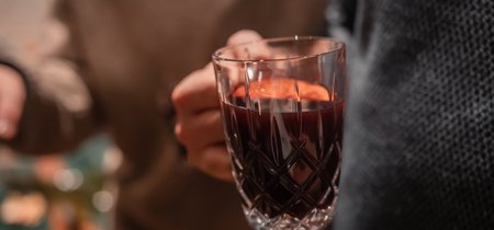 Person hält ein Glas mit Glühwein im Wellnesshotel im Harz
