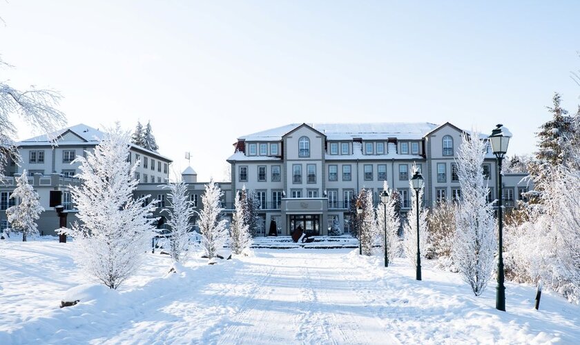 Der Weg von der Straße zum Wellnesshotel Schindelbruch im Winter mit blauem Himmel und Sonnenschein im Harz.