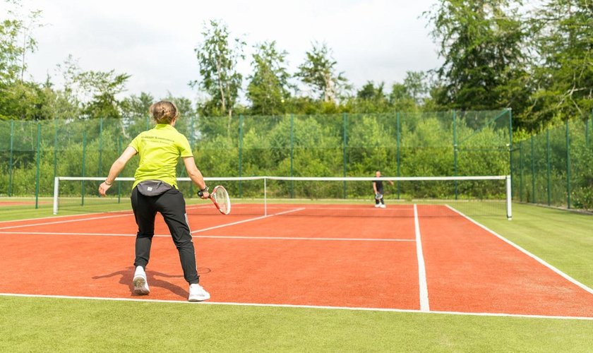 Tennisspieler im Aktivurlaub auf einem der zwei Tennisplätze im Naturresort Schindelbruch im Harz