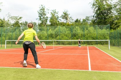 Tennisspieler im Aktivurlaub auf einem der zwei Tennisplätze im Naturresort Schindelbruch im Harz
