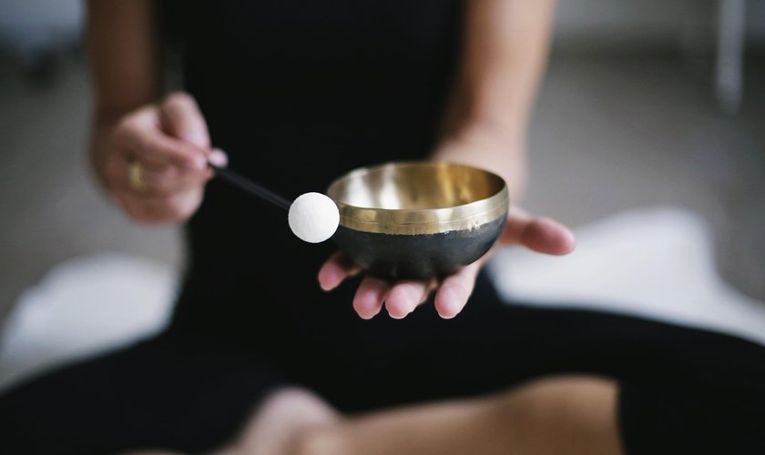 Die Kursleiterin hält eine Klangschale in der Hand zum Einstimmen in das Retreat im Schindelbruch zur Klangschalenreise.